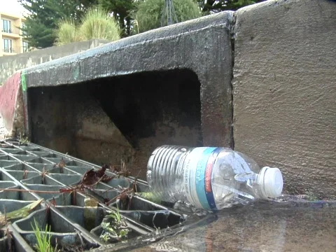 Plastic bottle about to fall into storm drain Video stock 609710