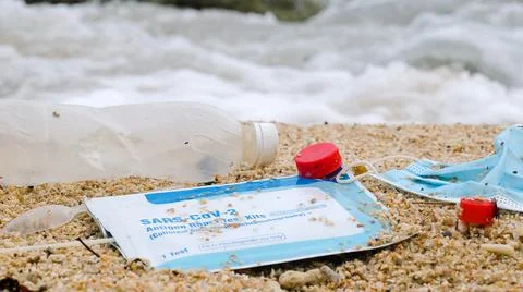 Plastic bottle and spoon, used face mask, self test for COVID-19 trash on the Stock Photos