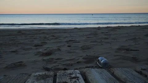 A plastic bottle on the beach, with the sea and a kayaker in the background Stock Footage 328388891