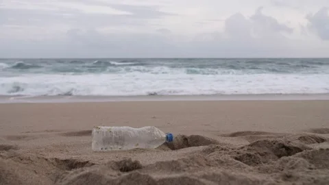 Plastic bottle on the beach, sea in the background Stock Footage 198399593