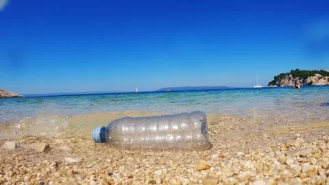 Plastic bottle on the beach shows impact of marine plastic waste Video stock 340120929