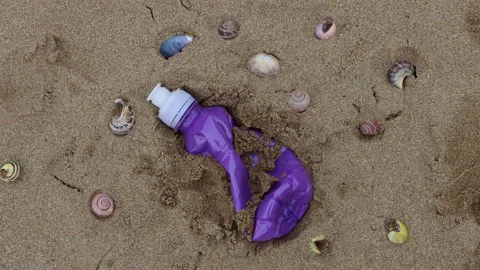 Plastic bottle being picked up on Woolacombe beach in Devon, UK Stock Footage 170307686