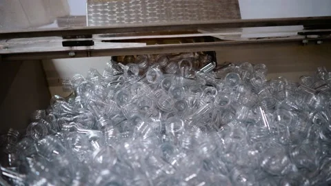 Plastic bottle blanks fall into the plastic packaging machine Stock Footage 200382324