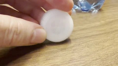 Plastic Bottle Cap with Recycle Sign Dropped on Table Vidéo 332839808