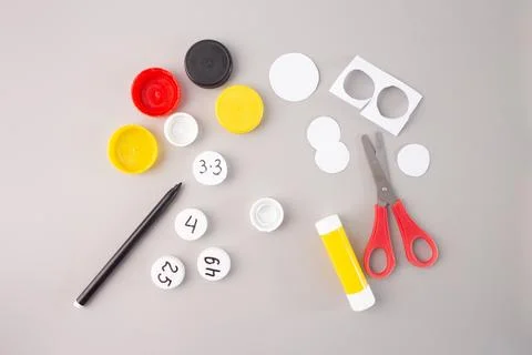 Plastic bottle caps with hand-written numbers and multiplication facts on a.. Stock Photos