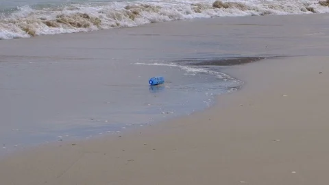 Plastic bottle container on ocean sea shore waves, planet water pollution repor Stock Footage 117108339