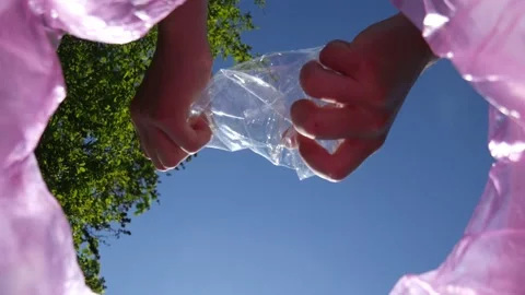Plastic bottle crushed by a man's hands and thrown into a trash bag Close up Stock Footage 153830982