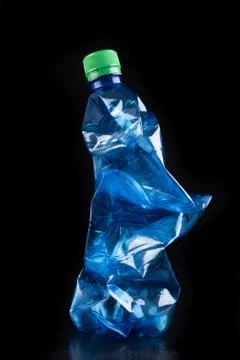 Plastic bottle on a dark table. Plastic container for drinking water. Stock Photos