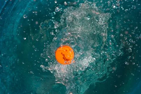 Plastic bottle falling into the water making splashes and spraying drops Foto stock
