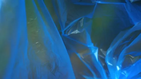 A plastic bottle falls into a blue trash bag. Close-up. Stock Footage 132136761