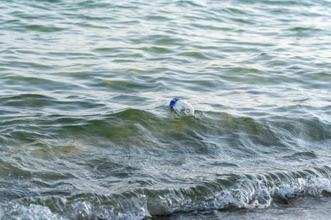 Plastic bottle floating in the ocean. Concept of pollution and garbage being Stock Photos