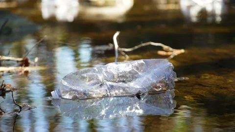 Plastic bottle floating in a river Stock Footage 236882824