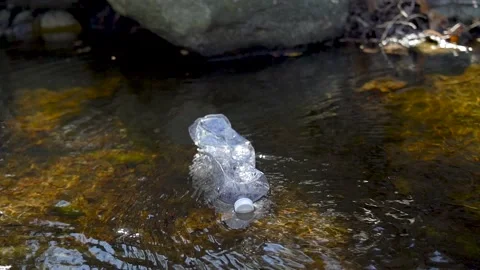 Plastic bottle floating in a river Stock Footage 236902849