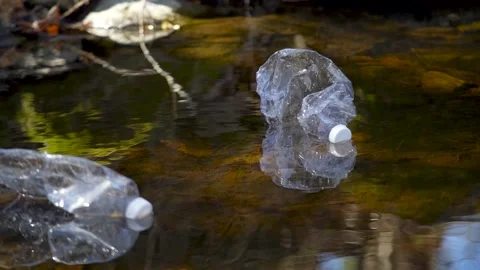 Plastic bottle floating in a river Stock Footage 236903636