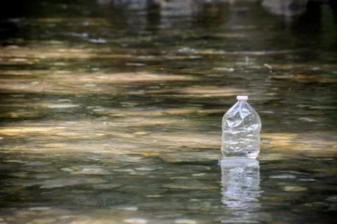 A plastic bottle floating in the river Stock Photos