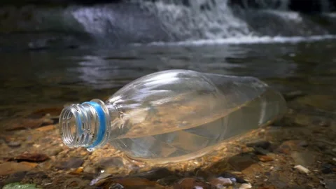 Plastic bottle in forest river, plastic waste floating in water, environmental Stock Footage 158100488
