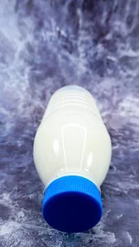 A plastic bottle of fresh regular milk on a dark gray marbled or concrete bac Stock Photos