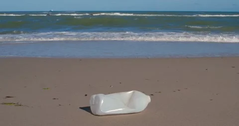 Plastic bottle in front of beautiful beach and ocean Stock Footage 145919218