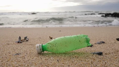 Plastic bottle garbage lie on a sand of Atlantic ocean beach in Portugal Stock Footage 227700092