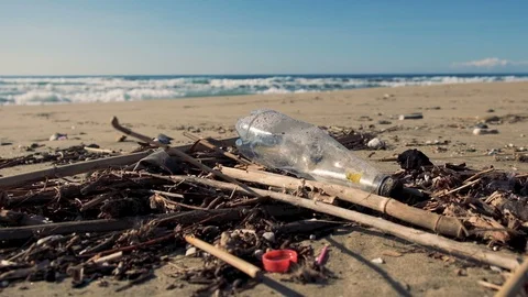 Plastic bottle garbage on polluted beach over sea waves motion background, 4k Stock Footage 120423152