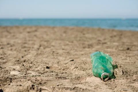 Plastic bottle left on a sandy beach. Stock Photos