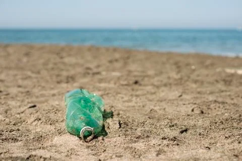 Plastic bottle left on a sandy beach. Stock Photos