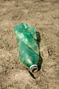 Plastic bottle left on a sandy beach. Stock Photos
