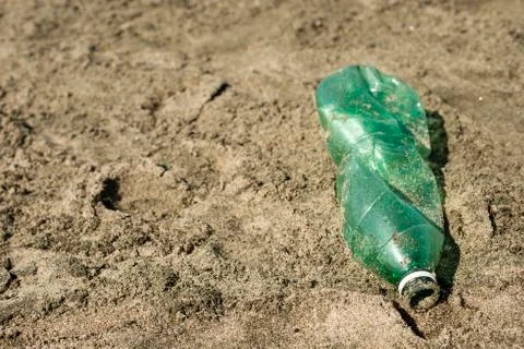 Plastic bottle left on a sandy beach. Stock Photos