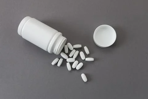 Plastic bottle with multivitamins on gray background Stock Photos