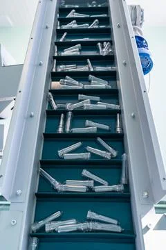 Plastic bottle necks on an automatic lift. Part of the production line. Stock Photos