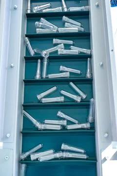 Plastic bottle necks on an automatic lift closeup. Stock Photos