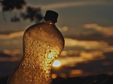 Plastic bottle pierced by the sun's rays Stock Photos