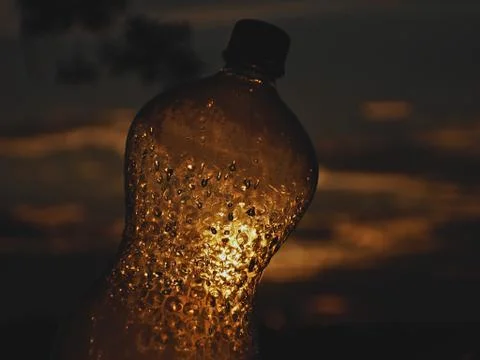 Plastic bottle pierced by the sun's rays Stock-Fotos