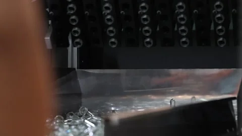 Plastic bottle preforms on conveyor belt in automated manufacturing system. Stock Footage 313344781