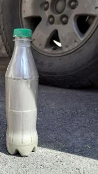 Plastic bottle with silver metallic touch up paint near car wheel. 写真素材