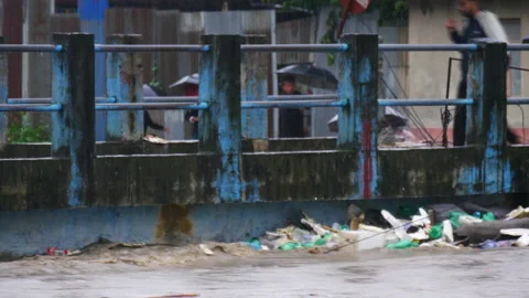 Plastic bottles and pollution getting stuck under the bridge during flood Stock Footage 286017664