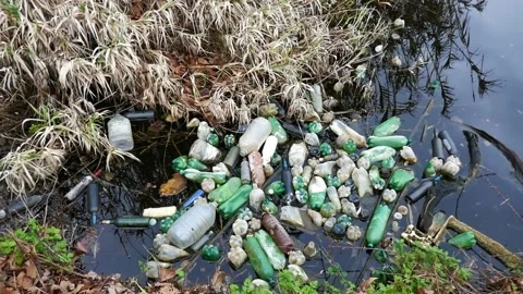 Plastic bottles and trash in a polluted river. Water contamination Stock Footage 150970338