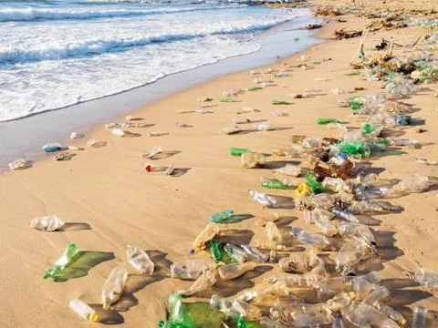 Plastic bottles and waste washed up by the sea cover the entire beach Stock Photos