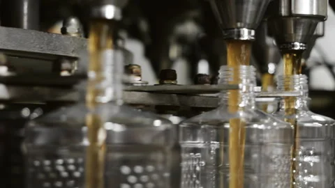 Plastic bottles are automatically filled with liquid. Stock Footage 284316395