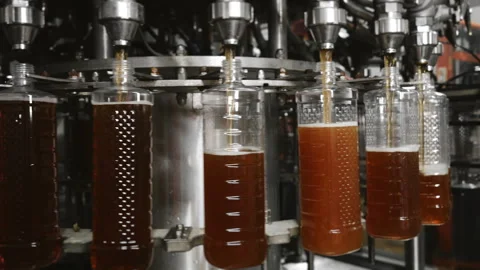 Plastic bottles are automatically filled with liquid. Stock Footage 284317034