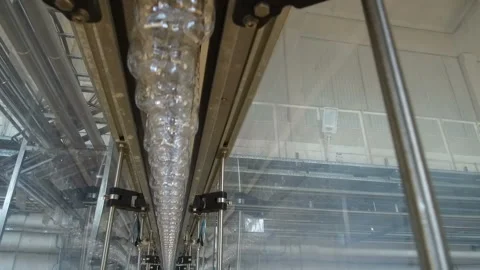 Plastic bottles are moving along the conveyor for filling Stock Footage 98713997