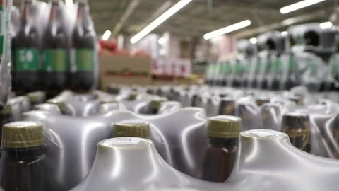 Plastic bottles with beer, wrapped in cellophane packaging, in the store. Stock Footage 258381982