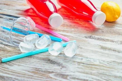 Plastic bottles with berries, refreshing drink. scattered ice cubes and drink Stock Photos