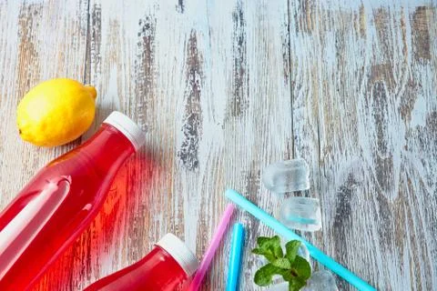 Plastic bottles with berries, refreshing drink. scattered ice cubes and drink Stock Photos