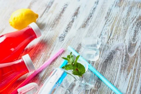 Plastic bottles with berries, refreshing drink. scattered ice cubes and drink Stock Photos