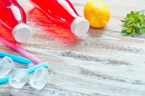 Plastic bottles with berries, refreshing drink. scattered ice cubes and drink Stock Photos