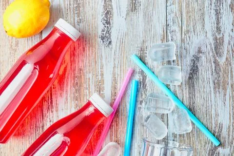 Plastic bottles with berries, refreshing drink. scattered ice cubes and drink Stock Photos