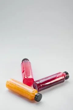 Plastic bottles of cold-pressed unprocessed fruit and vegetable juices, light Stock Photos