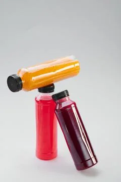 Plastic bottles of cold-pressed unprocessed fruit and vegetable juices, light Stock Photos