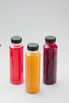 Plastic bottles of cold-pressed unprocessed fruit and vegetable juices, light Stock Photos